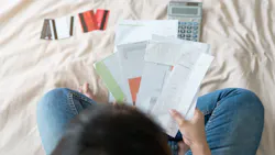 A homeowner goes over her bills as housing costs rise.