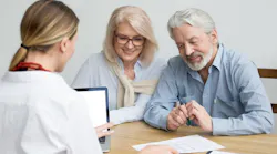 A Baby Boomer couple discussing purchasing a home with a real estate agent.