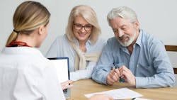 A Baby Boomer couple discussing purchasing a home with a real estate agent. A Baby Boomer couple discussing purchasing a home with a real estate agent.