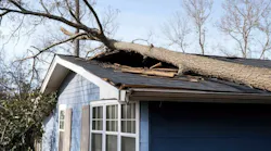 A tree on top of the roof of a home after a tornado, as the U.S. sees an increase in extreme weather events and homeowners worry about their insurance coverage.