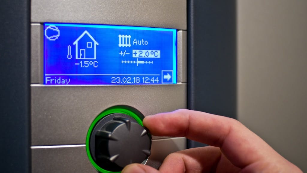 A homeowner changes the temperature on their thermostat