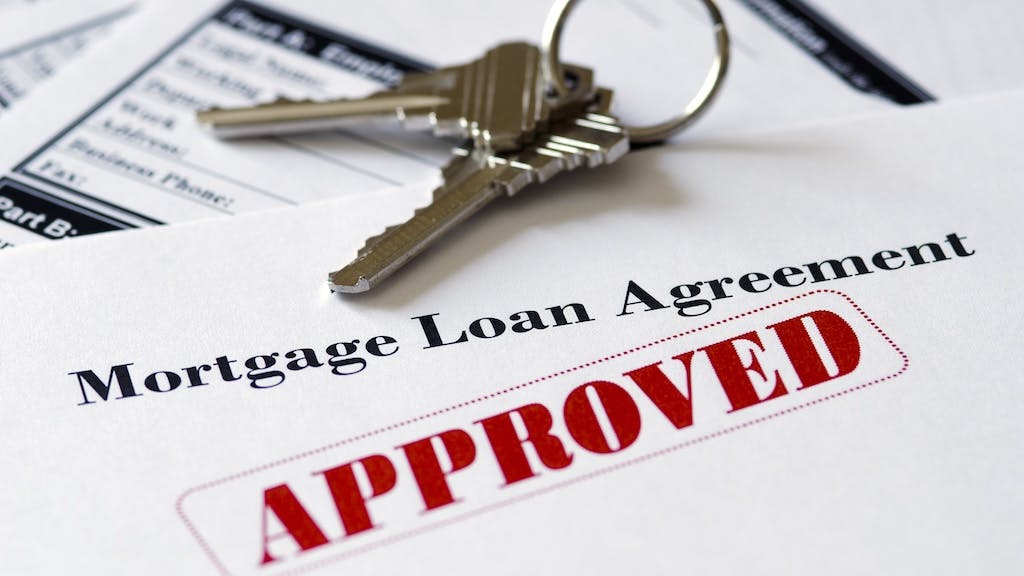 Mortgage application with the word 'Approved' stamped onto it in red ink.