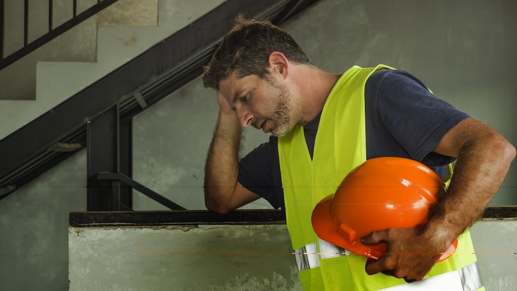 A stressed construction worker represents the challenges the construction industry faces regarding mental health.