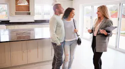 A real estate agent shows prospective homebuyers around a home