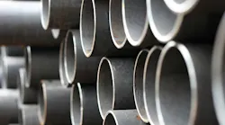 Closeup of stacked metal pipe as construction costs rise.