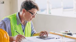 A builder calculating costs for rental construction. A builder calculating costs for rental construction.