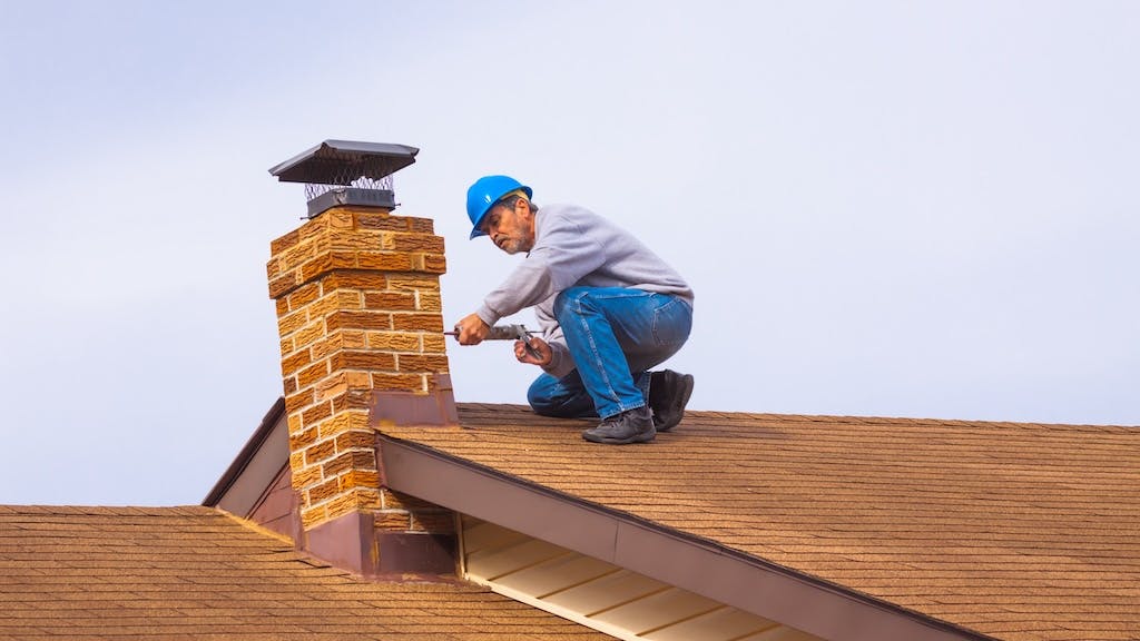 Home builder working on a roof as builders feel uncertain about economic prospects.