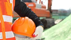 Closeup of hard hat being held by construction worker as part of on-site safety measures. Closeup of hard hat being held by construction worker as part of on-site safety measures.