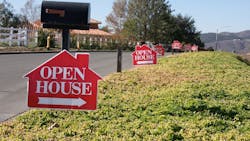 Open house signs along a street point toward homes for sale as existing-home sales decrease. Open house signs along a street point toward homes for sale as existing-home sales decrease.