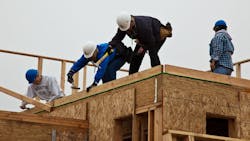 Construction workers on the roof of a home Construction workers on the roof of a home