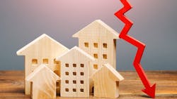 An arrow descending next to several wooden model homes indicates falling home prices An arrow descending next to several wooden model homes indicates falling home prices