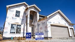 A newly built home with a 'For Sale' sign in the front yard A newly built home with a 'For Sale' sign in the front yard