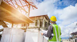 Home builder looks over plans at a jobsite as wage growth for residential professionals slows.