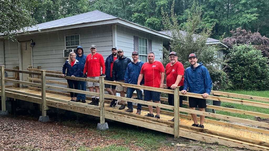 Mungo Homes staff and Home Works workers stands outside a home in Columbia, S.C.