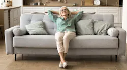 Homeowner relaxes on her couch, enjoying low monthly housing payment