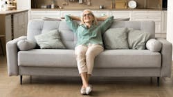 Homeowner relaxes on her couch, enjoying low monthly housing payment Homeowner relaxes on her couch, enjoying low monthly housing payment