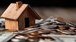 Wooden model home sits on a stack of cash, symbolizing high levels of home equity