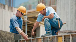 Two high-earning construction workers collaborate at a jobsite
