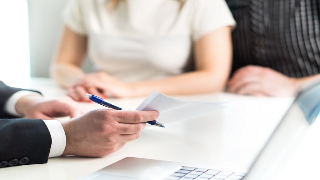 Homebuyers look over paper work with their real estate agent, ultimately changing their mind about buying a home