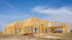 New construction framing against a blue sky