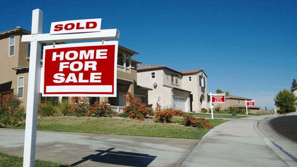 New-construction homes with 'For Sale' signs in the front yard
