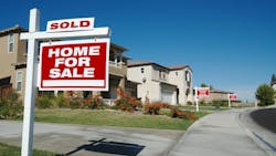 New-construction homes with 'For Sale' signs in the front yard New-construction homes with 'For Sale' signs in the front yard