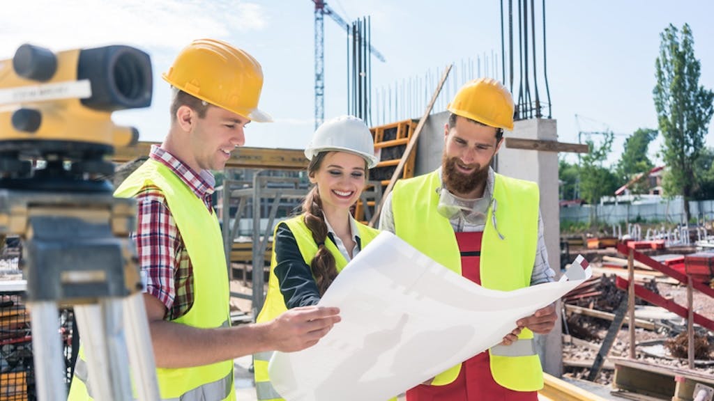 A group of three young construction workers at a jobsite together
