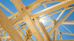 Abstract image of a home under construction, with the sky and sun peeking through