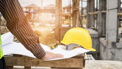 Construction worker looks over plans Construction worker looks over plans