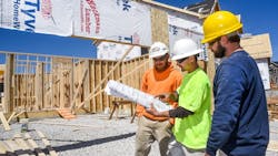 Builders working together at a construction site Builders working together at a construction site