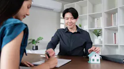 Homebuyer signs papers with a real estate agent