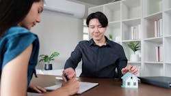Homebuyer signs papers with a real estate agent Homebuyer signs papers with a real estate agent