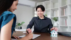 Homebuyer signs papers with a real estate agent