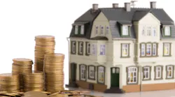 Model home sits next to coins, indicating household real estate value
