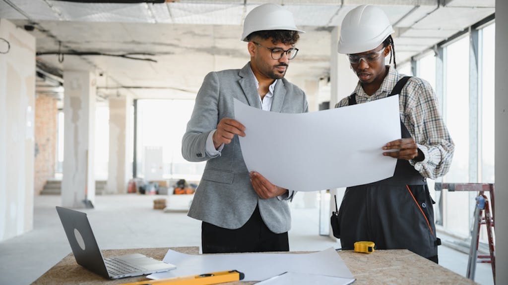 Builders look over house plan