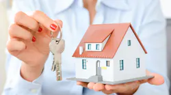 Real estate agent holding up model home and house key