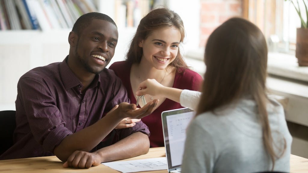 Young couple speaks with real estate agent