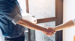 Construction worker shakes hands with employer after being hired