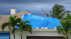 Roof of home covered with tarp after being damaged in hurricane