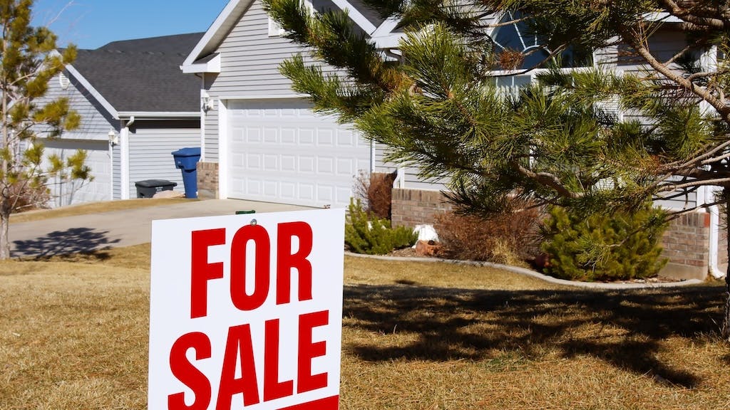 'For Sale' sign in front of single-family home