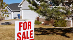 'For Sale' sign in front of single-family home
