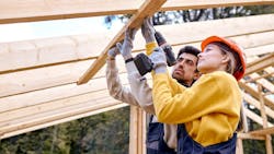 Two home builders working side by side Two home builders working side by side