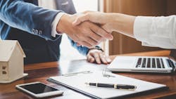 Homebuyer shakes hands with real estate agent after closing on a home Homebuyer shakes hands with real estate agent after closing on a home