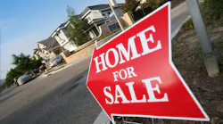 A red sign pointing to a home for sale