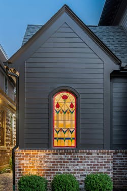 An antique stained-glass window found by the owners adds historic charm to the front elevation. An antique stained-glass window found by the owners adds historic charm to the front elevation.