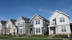 A row of newly-constructed homes on a suburban street A row of newly-constructed homes on a suburban street