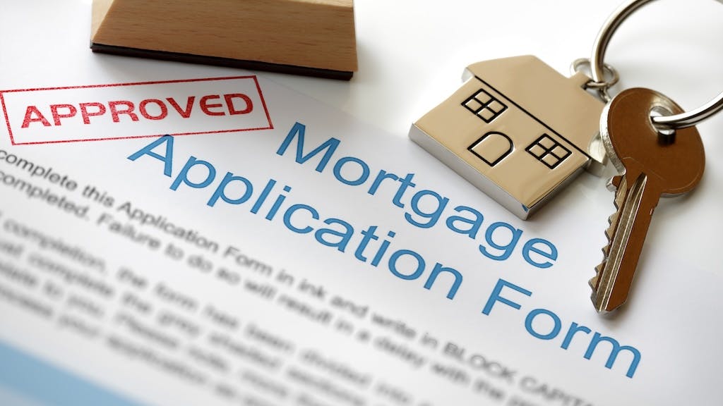 Mortgage application form with a set of house keys and a red stamp that reads 'approved'