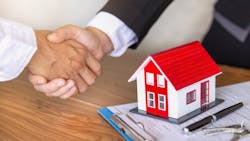 An investor shakes hands with a real estate agent after buying a home An investor shakes hands with a real estate agent after buying a home