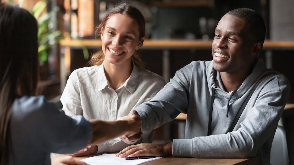 First-time homebuyers speak with a real estate agent