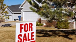 A 'For Sale' sign in front of a suburban home A 'For Sale' sign in front of a suburban home